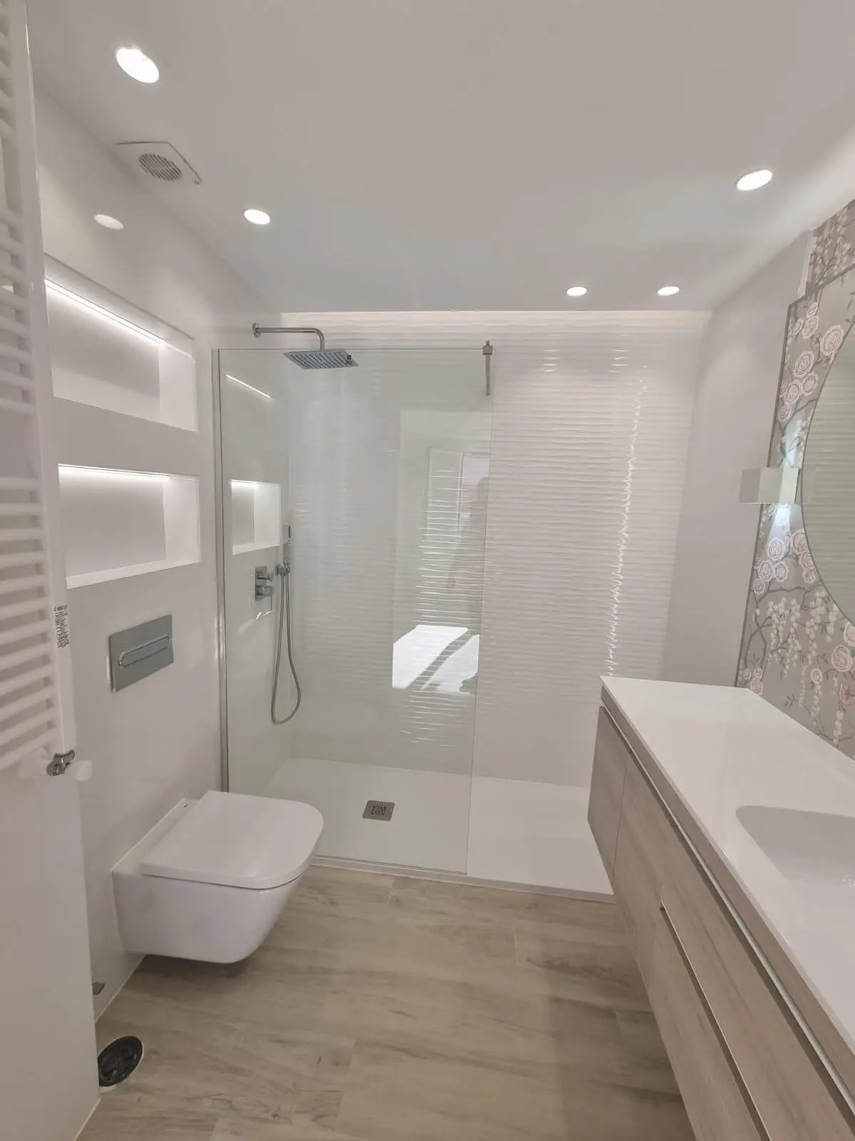Reforma baño con ducha de obra, mampara de cristal y sanitario suspendido en Madrid